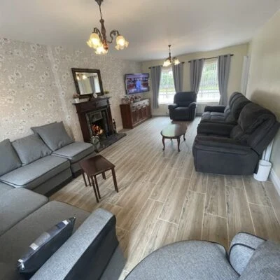 Redory House - Spacious lounge area room with sofas and chairs seats 11 comfortably. Open fireplace with mirror above. In conor of room a 55inch smart TV is  mounted